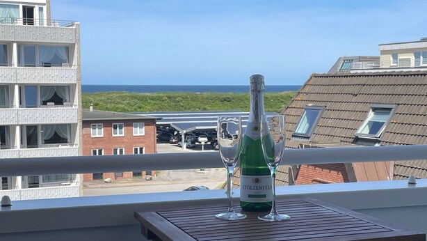 A balcony with a table, a bottle of Stolzenfels wine, and two glasses.