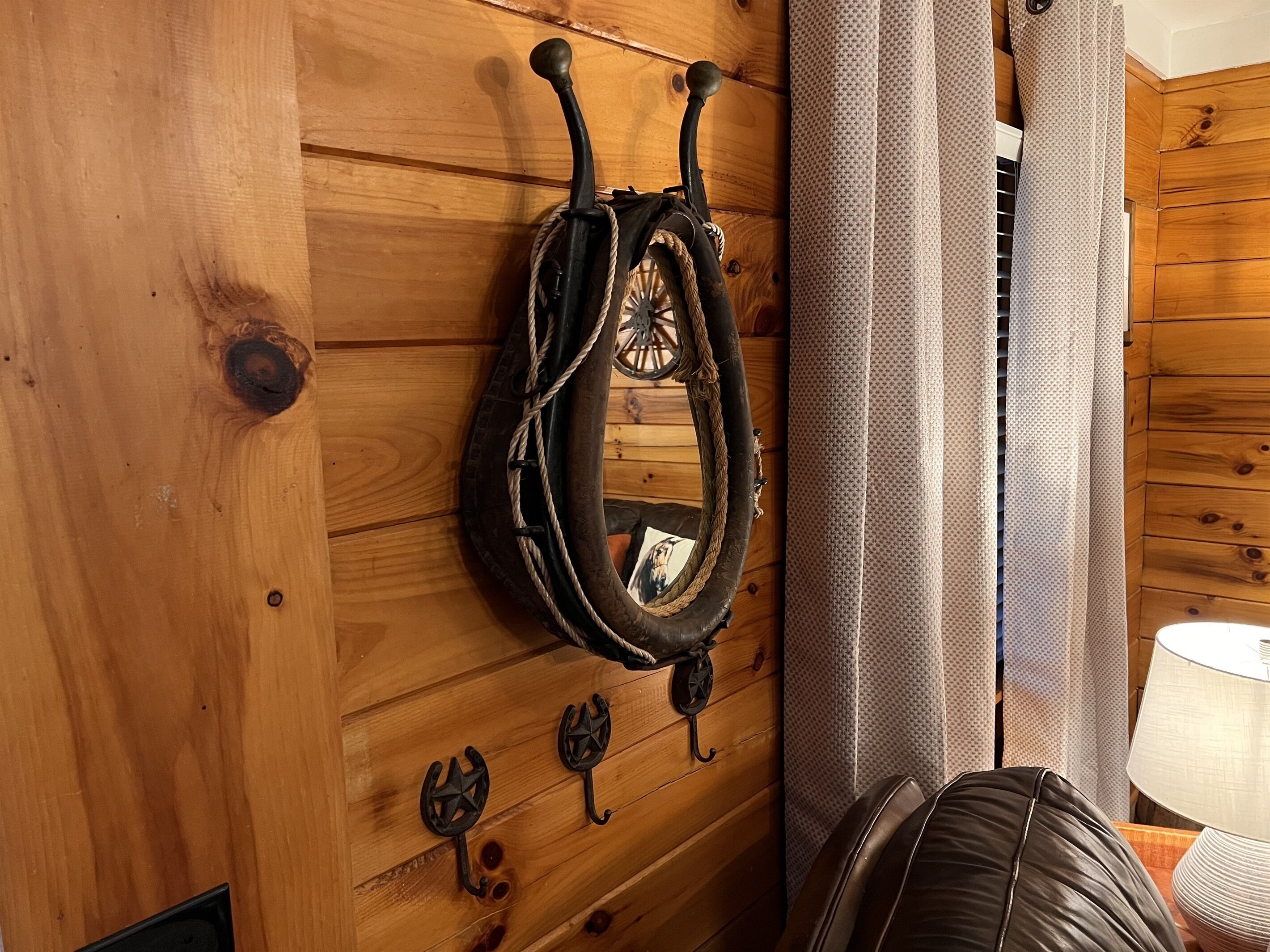 Pared de madera con una cuerda, una rueda, una lámpara y una silla.