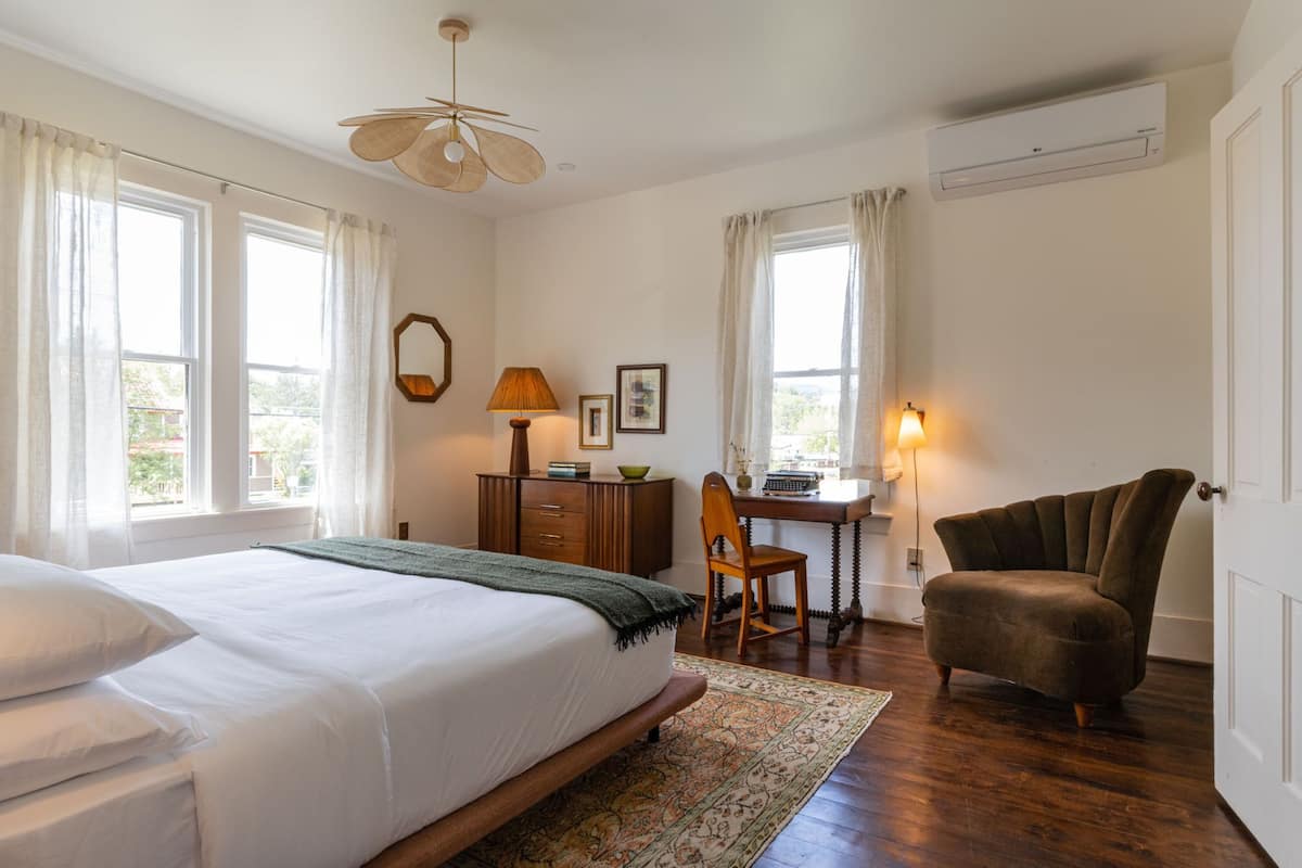 A bedroom with a bed, a desk, a chair, and a wardrobe.