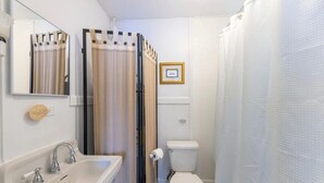 Een badkamer met een wastafel, toilet en douchegordijn.