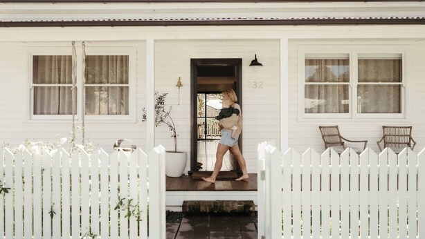 A white house with a porch, a white picket fence, and a number '132' on the door. - Luxe Historic River Port Stay - Pay 2, Stay 3* (Morpeth)
