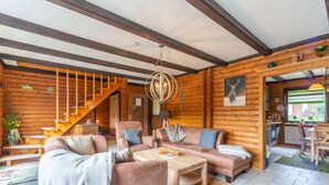 A cozy log cabin interior with a living room, a staircase, and a dining area. - Am Hohen Bogen by Interhome (Arrach)