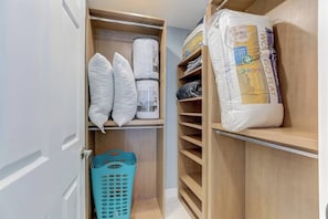 A closet with shelves holding pillows, a laundry basket, and storage bins. - *Modern 2/2 condo w/pool 6 mins to IMG* (Bradenton)