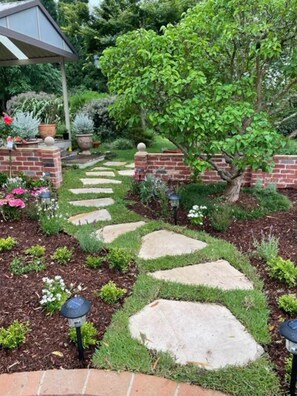 A garden pathway with stepping stones, brick walls, and various plants. - Martha's ......... Your hideaway in the highlands. (Burradoo)