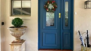 A blue door with a wreath, a potted plant, and a window above it. - Martha's ......... Your hideaway in the highlands. (Burradoo)