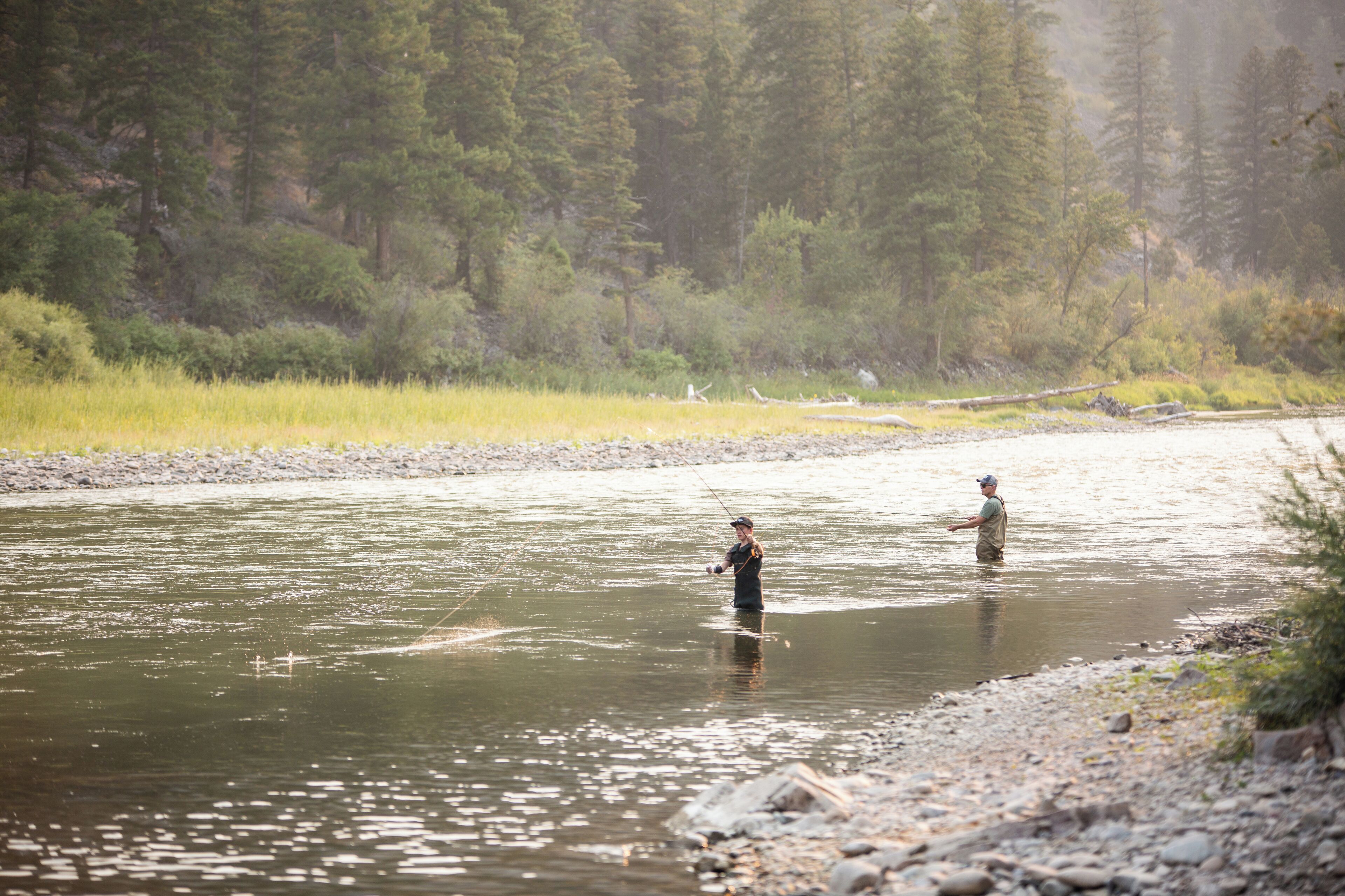 A river with two people fishing.