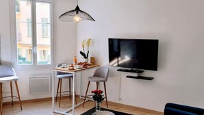 A modern living room with a TV, a dining table with chairs, a coffee table, and a sofa. - Ze Perfect Place - Comfortable 2 Bedroom Apartment - Asc - Port - Garibaldi (Nice)