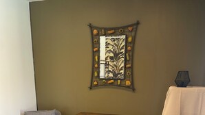 A room with two grey armchairs, a small wooden table, a decorative mirror, and a white tablecloth-covered table. - Vacations in Pomié (Baladou)