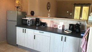 A kitchen with a refrigerator, microwave, toaster, coffee maker, and a sink. - Vacations in Pomié (Baladou)