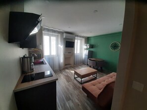 A compact living space with a kitchenette, a dining area, and a seating area. - "Les IRIS" APT 107, T2 COSY, 30 m2, 1 bedroom with TV (Bourg-Saint-Andéol)