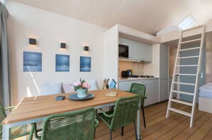 Cozy living space with a dining area, kitchenette, and lofted sleeping area.