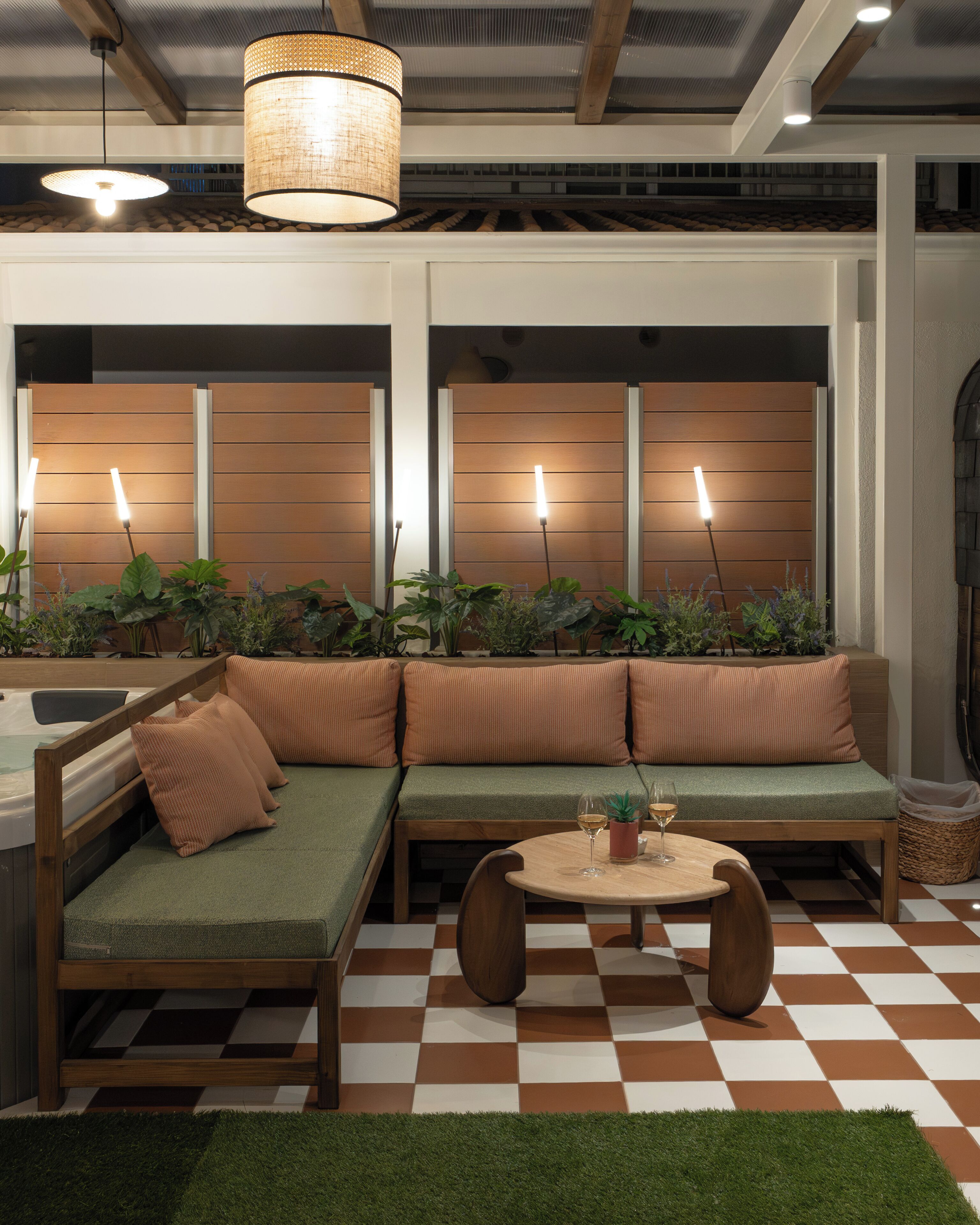 A modern interior with a sectional sofa, a round table, and a checkered floor.