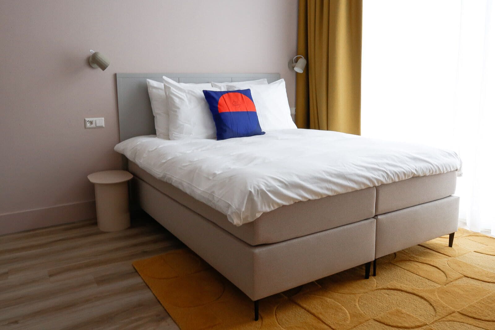 A modern bedroom with a bed, bedside table, and a nightstand.