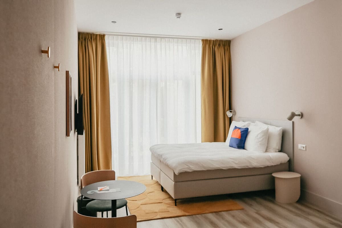 Ein kleines Hotelzimmer mit einem Bett, einem kleinen Tisch und einem Stuhl.