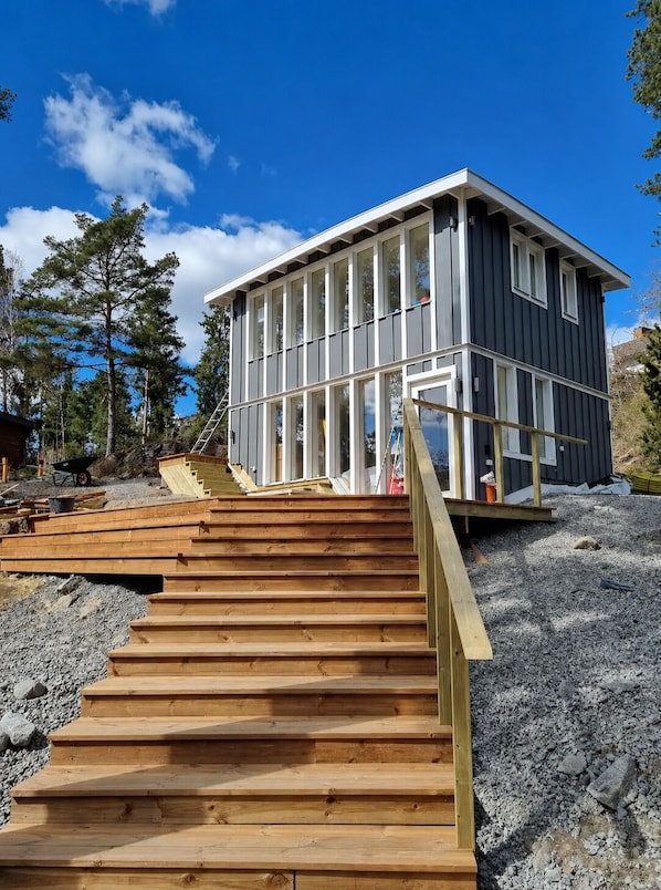 A modern building with a wooden staircase leading to a deck.