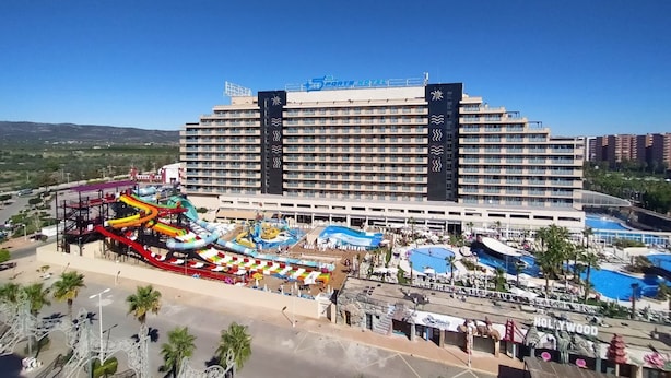 Un hotel grande con varios pisos, parque acuático y piscina.