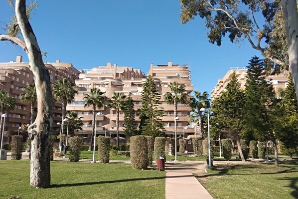 Stunning multi-story building surrounded by lush greenery and beautifully manicured gardens.