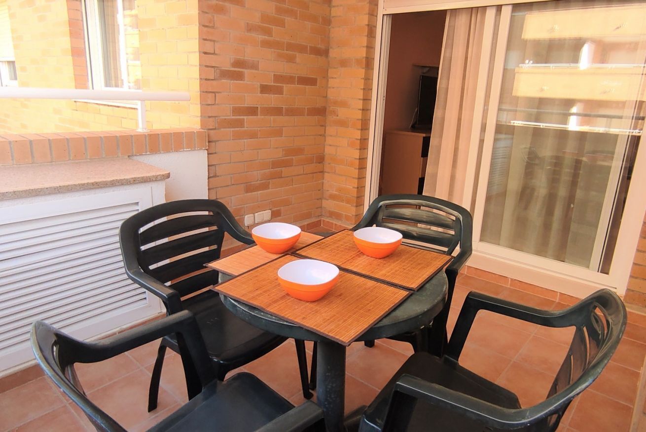 Een terras met een tafel en vier stoelen, elk met een schaal.
