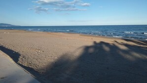 Una playa con cielo despejado y mar tranquilo.