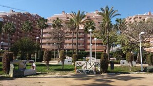 A residential building with multiple balconies, palm trees, and a well-maintained garden area. - ACV - Acapulco II-1ª linea planta 5 norte (OROPESA DEL MAR)