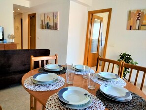 Une table à manger dressée avec des assiettes, des verres et un chemin de table en dentelle.