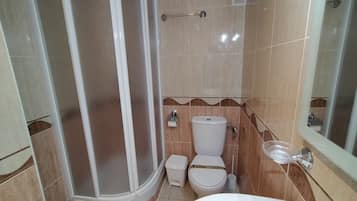 Un baño con ducha, inodoro y lavabo.