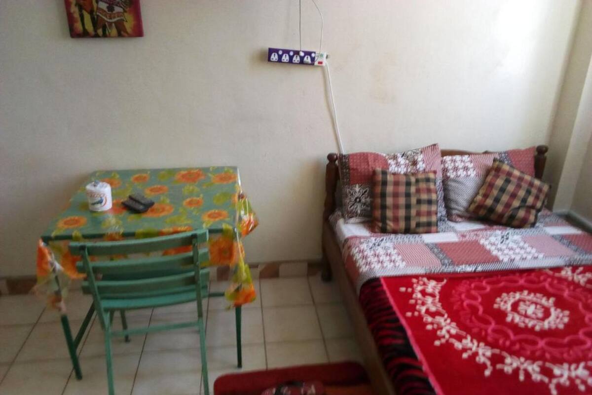 Una habitación pequeña con una cama, una mesa y una silla.