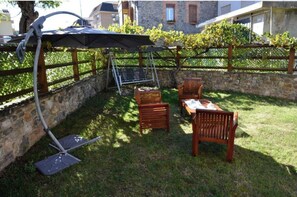 Relax in a tranquil setting with a pergola, swing, and dining area.