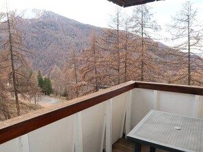 Een balkon met uitzicht op een bebost berglandschap.