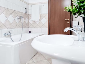 Bathtub, hair dryer, towels, shampoo