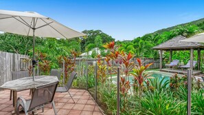 A backyard with a pool, patio furniture, and a gazebo. - Villa Latania (Palm Cove)