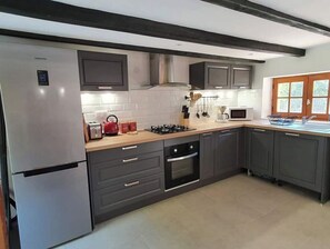 Enjoy cooking in this well-equipped kitchen with a refrigerator, oven, and microwave.