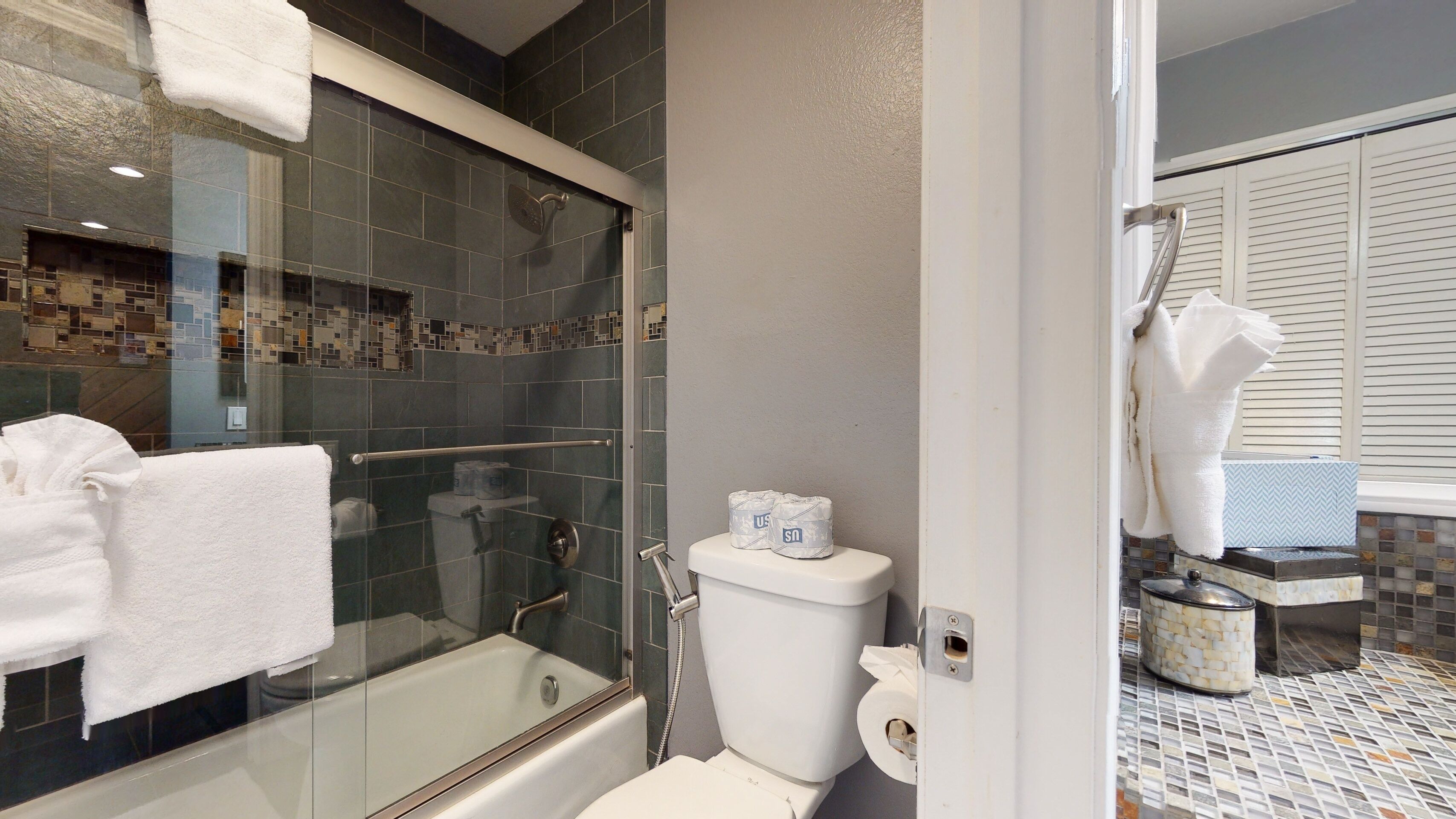 Une salle de bain moderne avec une douche à parois de verre, une baignoire et des toilettes.