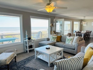 A living room with a view of the ocean, a ceiling fan, a dining area, and a sign indicating Wi-Fi availability. - Nothin But Nett 5 Bedroom Home by RedAwning (Supply)