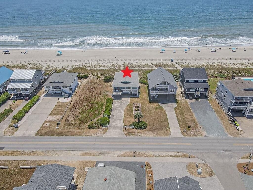 Un área residencial costera con casas, una playa y una carretera.