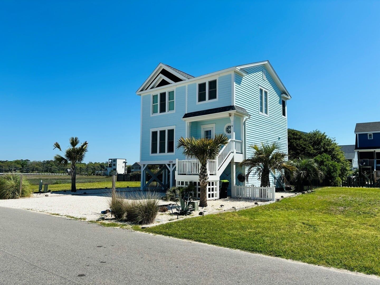 A two-story house with a porch and a staircase leading to the entrance.