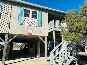 A two-story wooden building with a balcony and a covered entrance area.