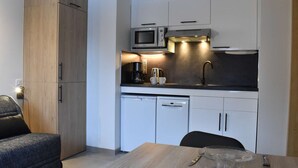 A compact kitchen with a microwave, coffee maker, and dishwasher.
