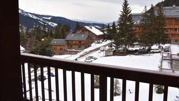A wooden lodge with a ski lift, surrounded by snow-covered mountains and trees.