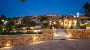 A hotel entrance with stone walls, a staircase, and outdoor lighting. - Villa Mariliza, ιδανική επιλογή για να αποδρά... (Argostoli)