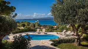 A swimming pool with lounge chairs and a view of the sea. - Villa Mariliza, ιδανική επιλογή για να αποδρά... (Argostoli)