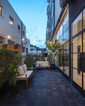 An outdoor patio area with seating and potted plants. - DeBlox living (Tel Aviv)