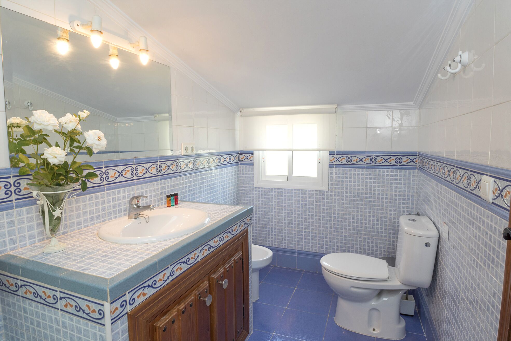 Een badkamer met een wastafel, spiegel en toilet.