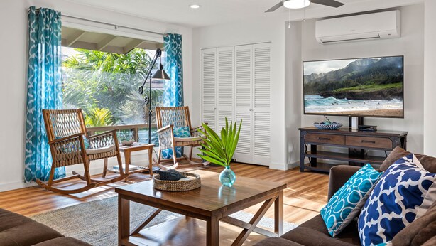A living room with a wooden coffee table, two rocking chairs, a sofa, and a television. - Perfect Family Beach House. Walk out gate to Amazing Beach. (Waialua)