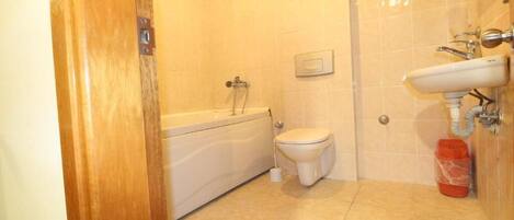 A bathroom with a bathtub, toilet, and sink.