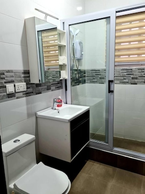 A modern bathroom with a glass shower enclosure, a white sink with a soap dispenser, and a toilet. - Spacious, Quiet & Cozy- Close to Highway-parking (Adenta)
