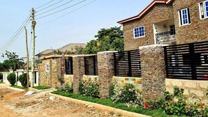 A two-story house with a stone facade, a red roof, and a gated entrance. - Cozy,quiet & Fantastic- Close to Highway - Parking (Adenta)