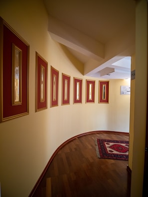 Un couloir doté d’un plancher en bois, de miroirs encadrés de rouge et d’un espace recouvert de moquette.