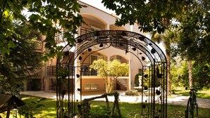 Un pati amb un arc de ferro forjat, una banca i una font.