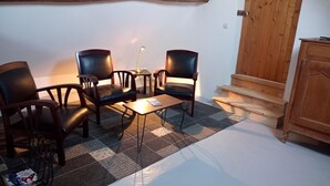 A cozy room with a checkered floor, wooden furniture, and a staircase leading to an upper level.